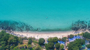 vista-aerea-della-spiaggia-di-sabbia-con-i-turisti-che-nuotano